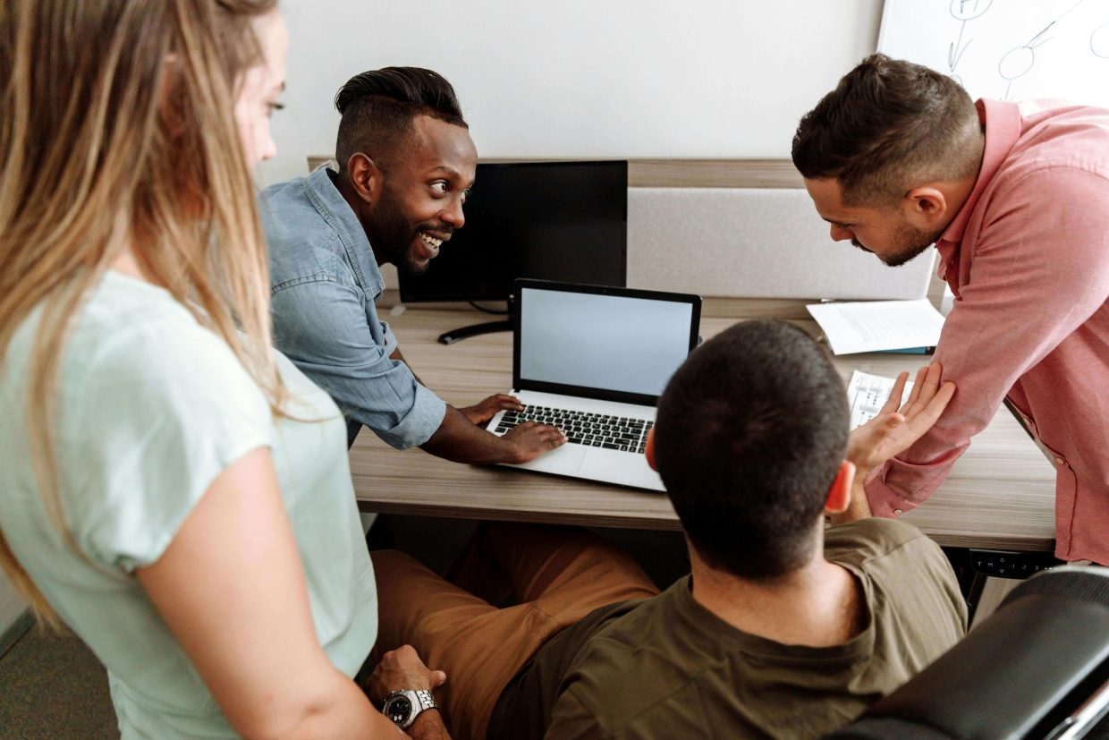 Diverse team of professionals seated around a conference table in a modern office exploring strategy.